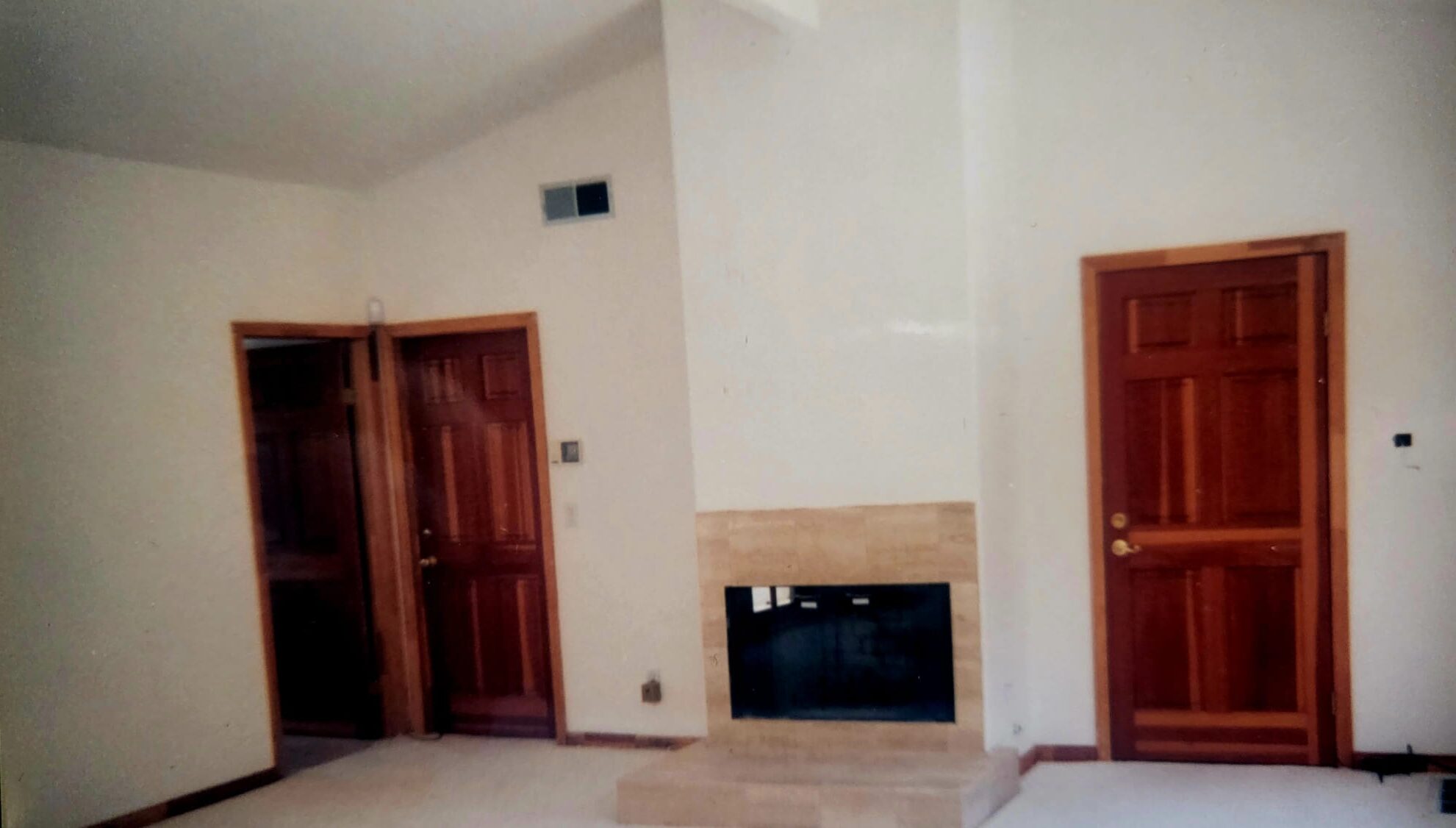 Interior after — finished room with fireplace, clean white walls and wood doors