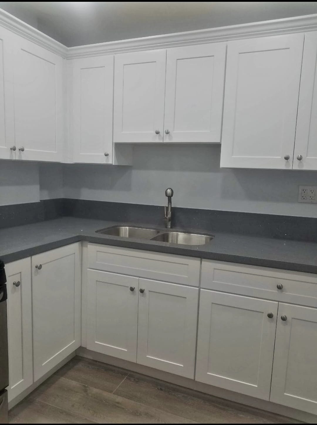 Kitchen after — white shaker cabinets, dark countertops and subway tile backsplash