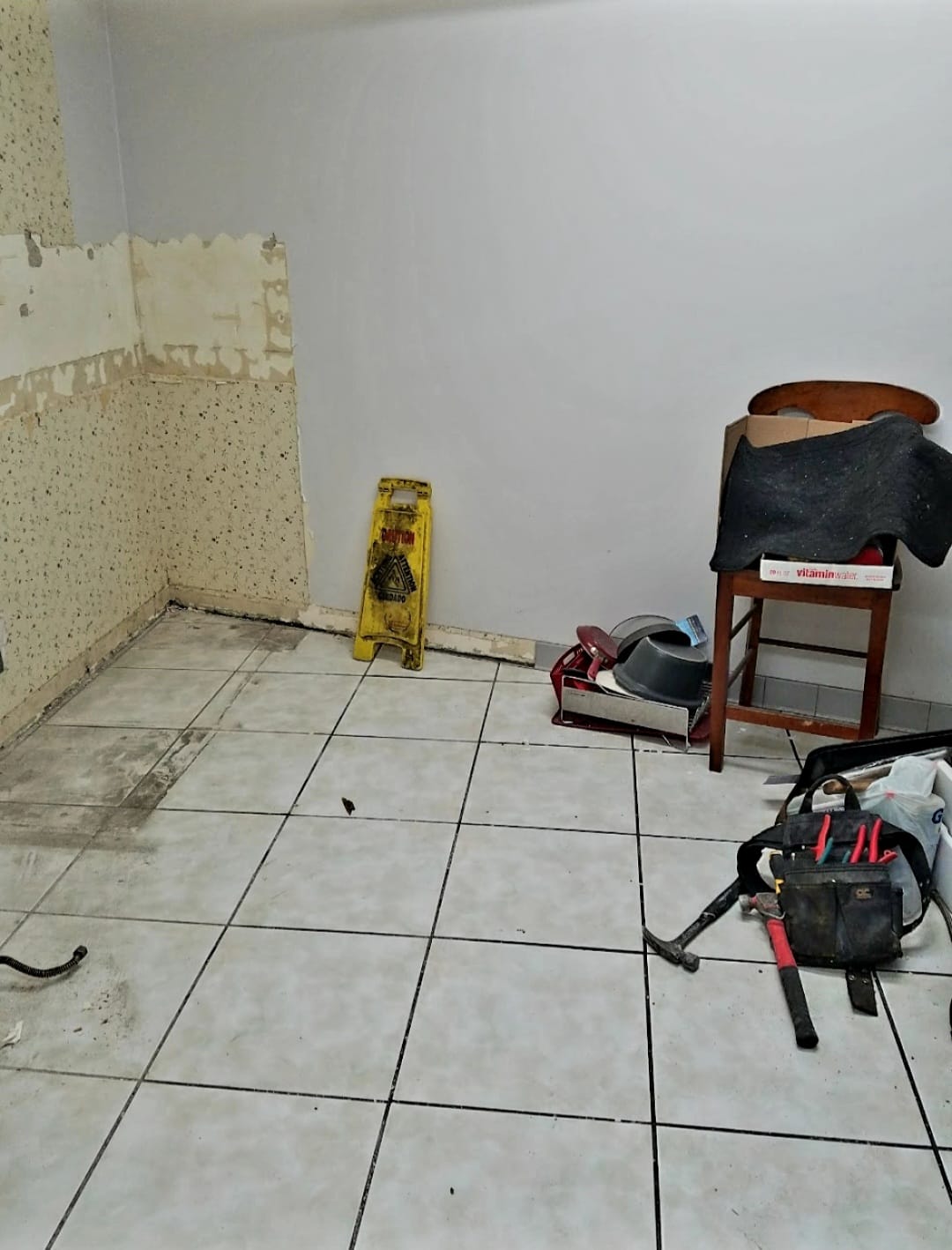 Kitchen before — room under renovation with tile floor and construction debris