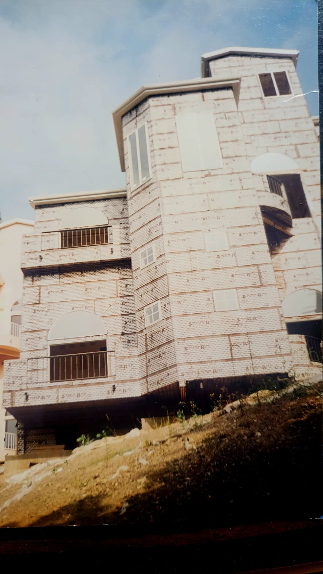 Building after — multi-story residential with curved balconies and brick exterior