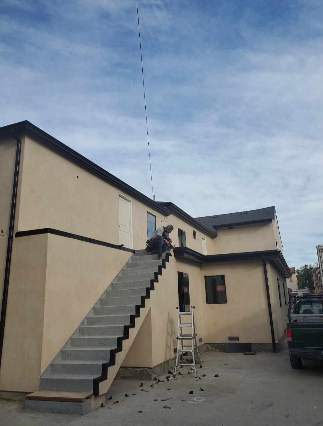 Building after — completed cream exterior with black trim and external staircase